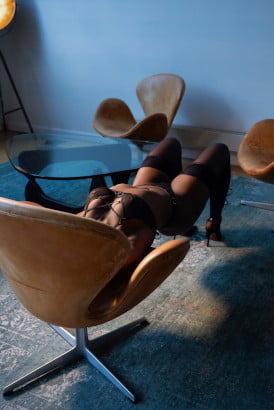 Sexy black girl using a chair to do a bridge pose