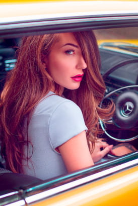 Redhead girl sitting in a yellow car